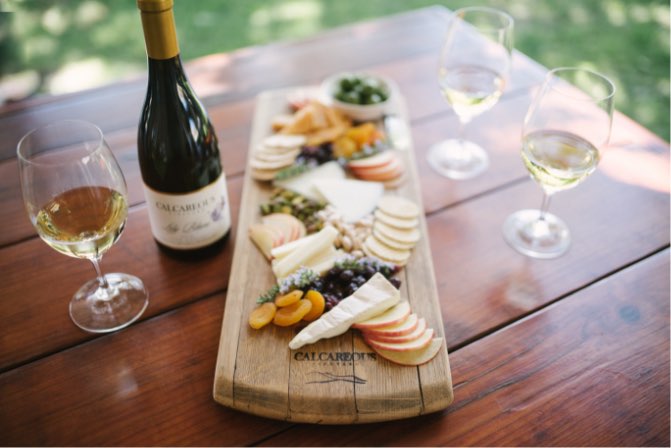A bottle and glass of chardonnay with a gourmet cheese plate at Calcareous Vineyard Winery in Paso Robles, CA