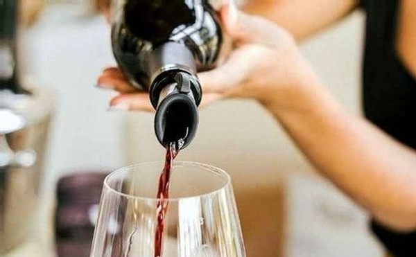 A wine bottle pouring a Calcareous red wine into a glass
