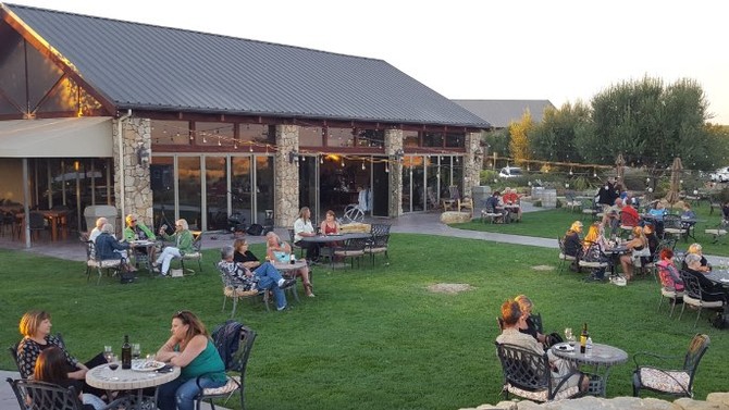 Guests wine tasting on the Calcareous lawn under a sunny Paso Robles afternoon