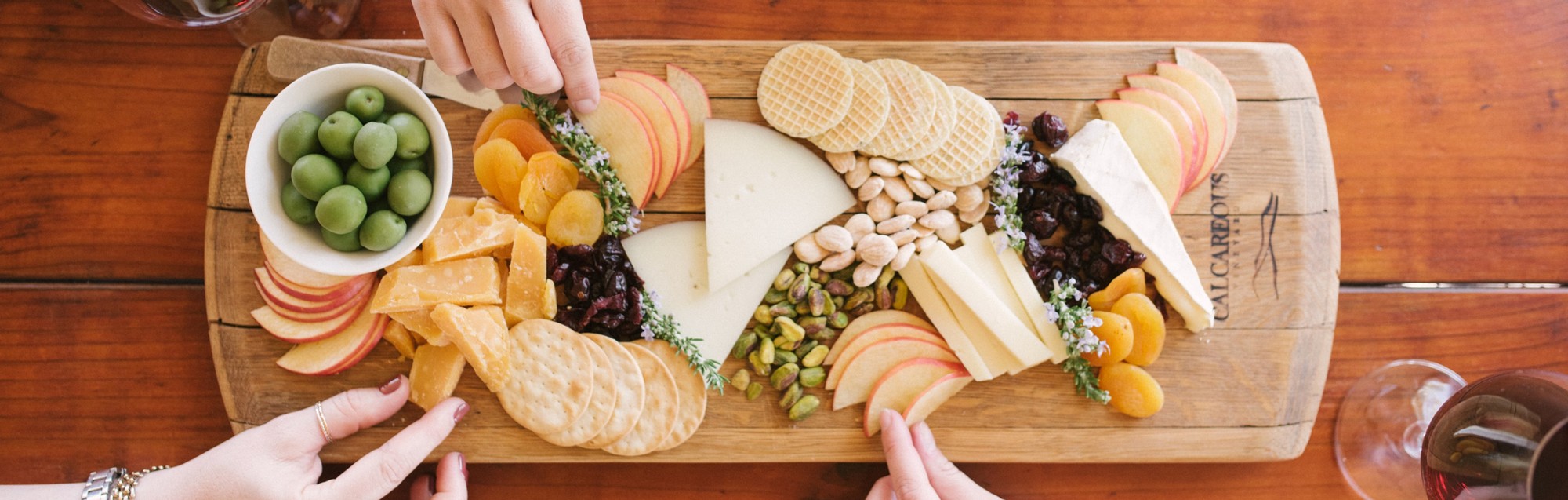 A gourmet cheese plate for wine tasting at Calcareous Vineyards in Paso Robles, with almonds, olives, dried apricots and various cheeses.