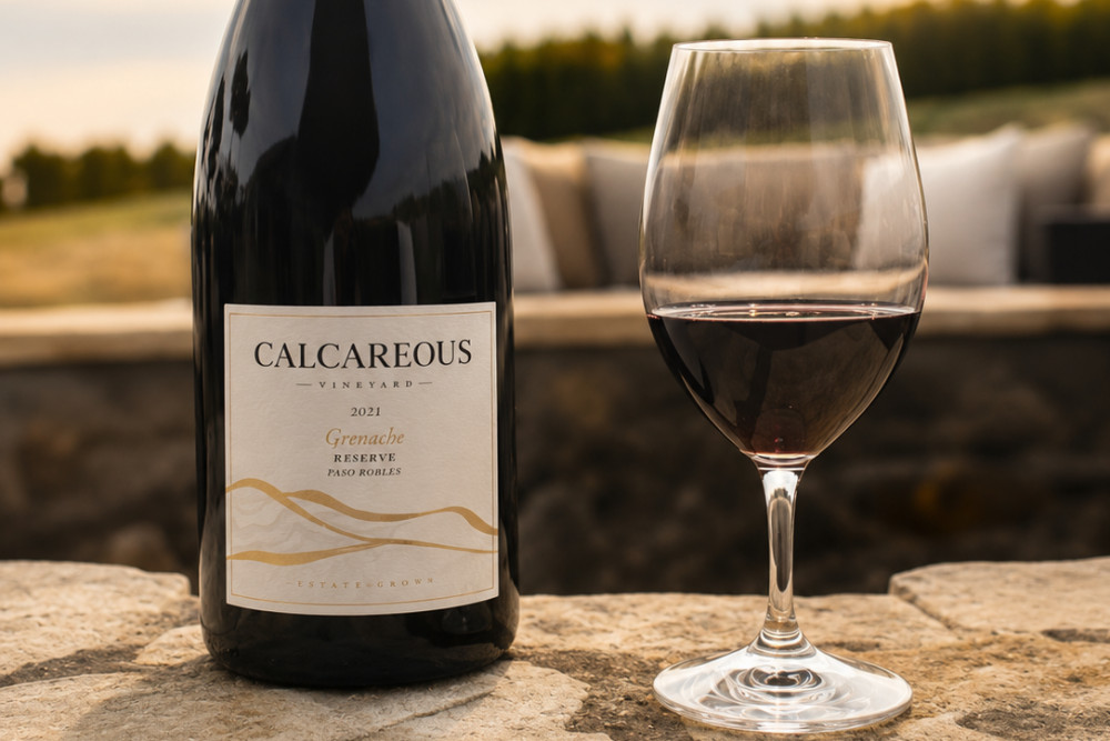 wine bottle with wine glass on a rock in the background